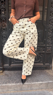 Pantalon à pois porté par une femme, silhouette entière, haut marron, grille noire