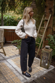Jeans mom coupe loose porté par une femme, silhouette entière, échelle, pull ivoire