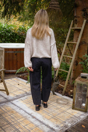 Jeans mom coupe loose porté par une femme, vue de dos, pull ivoire, échelle