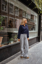 Jean flare taille haute porté par une femme, vue de trois-quarts, vitrine, pull marine