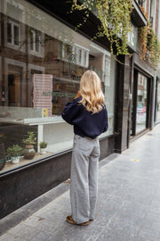 Jean flare taille haute porté par une femme, vue de dos, cheveux blonds, vitrine