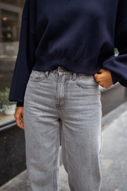 Jean flare taille haute porté par une femme, vue rapprochée, taille haute, mains dans les poches