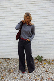 Jean large à coupe loose porté par une femme, silhouette entière, haut gris, sac