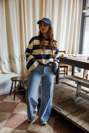 Jean large à côtés bicolores porté par une femme, vue de trois-quarts, casquette, devant