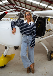 Jeans taille haute extensible porté par une femme, vue de trois-quarts, avion, pull rayé