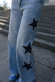 Jeans à étoiles perlées évasé porté par une femme, vue rapprochée, étoiles perlées, jambe
