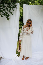 Jupe longue fluide doublée beige portée par une femme, vue de trois-quarts, panier, drapés
