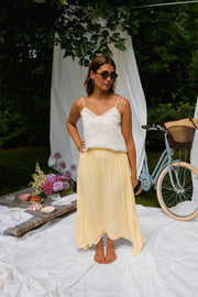 Jupe longue fluide doublée jaune portée par une femme, silhouette entière, vélo, drapés