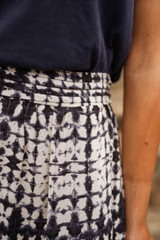 Jupe longue tie-dye fendue portée par une femme, vue rapprochée, tie-dye noir et blanc, taille
