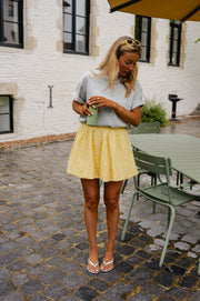 Jupe boule doublée portée par une femme, silhouette entière, terrasse, haut gris