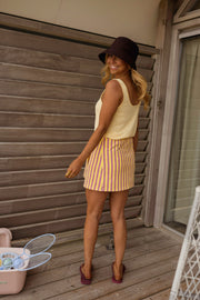 Jupe courte en éponge portée par une femme, silhouette entière, chalet, chapeau
