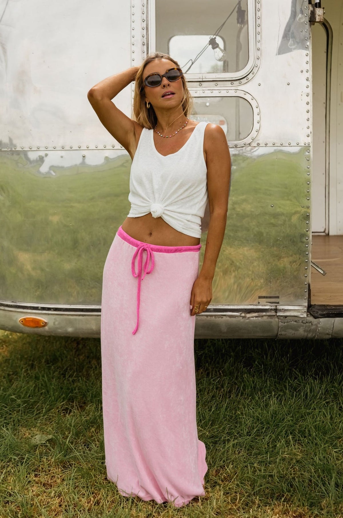 Jupe longue en éponge portée par une femme, silhouette entière, caravane, ceinture rose vif