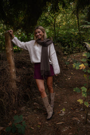 Jupe-short zippée sur le côté porté par une femme, silhouette entière, écharpe grise, bottes