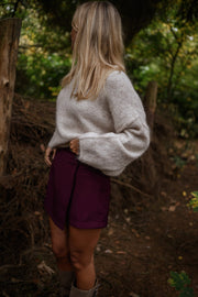 Jupe-short zippée sur le côté porté par une femme, vue de profil, forêt, cheveux blonds