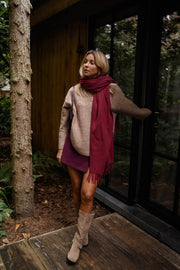 Jupe-short zippée sur le côté porté par une femme, silhouette entière, écharpe rouge, porte vitrée