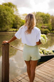 Jupe-short courte à fermeture latérale porté par une femme, vue de dos, ponton, bouquet