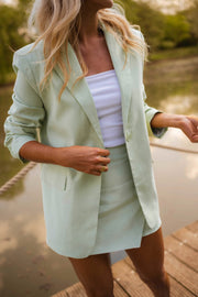 Jupe-short courte à fermeture latérale porté par une femme, vue de trois-quarts, blazer vert d'eau, jupe-short