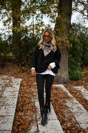 Legging moulant fendu porté par une femme, silhouette entière, veste noire, feuilles