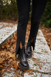 Legging moulant fendu porté par une femme, vue rapprochée, fente, bottines