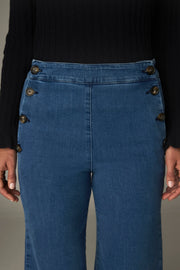 Détail de la taille haute et des deux rangées de boutons du jean bleu