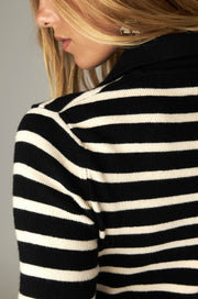 Détail arrière du col noir et de l'épaule du pull à rayures écrues