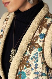 Gilet imprimé à broderies contrastées — gros plan bordure moelleuse et broderies