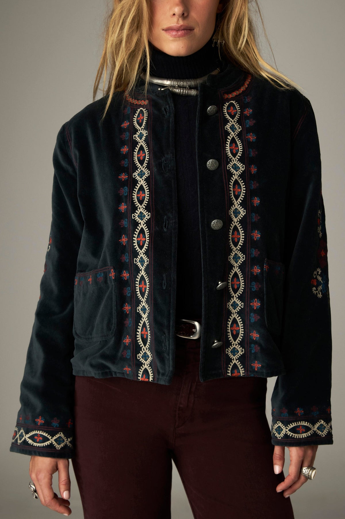 Veste sombre boutonnée à motifs multicolores sur le devant, les poches et les poignets.
