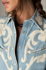 Détail du col, des boutons et des motifs crème sur la poitrine de la chemise bleu clair
