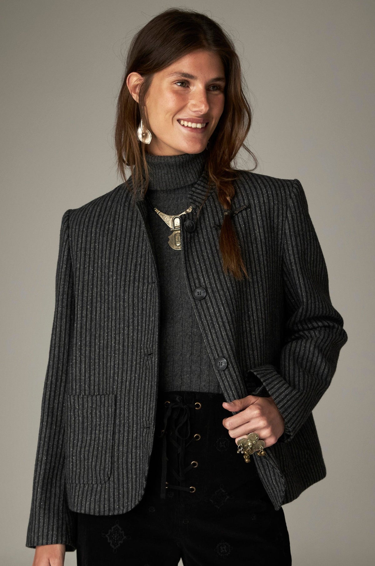 Veste gris foncé à fines rayures verticales, boutons et poches devant, portée de face.