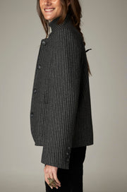 Veste gris foncé à fines rayures, portée de profil.