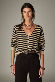 Cardigan à rayures noires et écrues, col V et boutons clairs, porté de face.