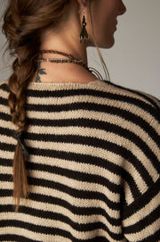Détail de l'encolure au dos et des rayures noires et écrues du cardigan.