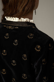Détail des broderies dorées au dos du col et sur les épaules de la veste noire.