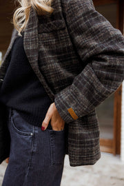 Manteau à carreaux doublé porté par une femme, vue rapprochée, carreaux, main dans la poche