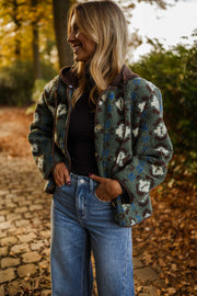 Manteau polaire à capuche amovible porté par une femme, vue de face, allée pavée, mains dans les poches