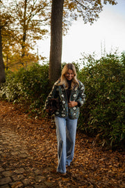 Manteau polaire à capuche amovible porté par une femme, silhouette entière, allée pavée, feuilles d'automne