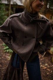 Manteau doublé à revers montant marron porté par une femme, vue rapprochée, col montant, boutons