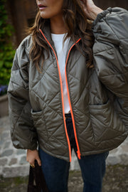 Manteau imperméable matelassé kaki porté par une femme, vue rapprochée, matelassé, col relevé