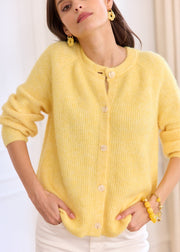 Gilet jaune en laine — vue portée de face, mains au niveau de l'ourlet