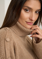 Détail du col roulé et des boutons sur l'épaule du pull camel