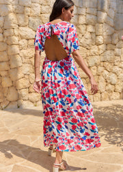 Robe longue à fleurs roses et bleues, portée de trois quarts dos avec une grande ouverture dans le dos.