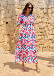 Robe longue à fleurs roses et bleues, portée de face, avec manches courtes et taille marquée.