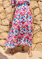 Robe longue fleurie rose et bleue, cadrée du buste aux pieds.