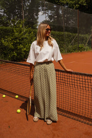 Pantalon fluide à pois porté par une femme, silhouette entière, court, filet