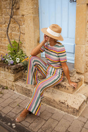 Pantalon crochet taille haute porté par une femme, assise, marches en pierre, chapeau