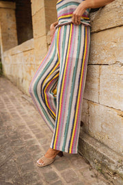 Pantalon crochet taille haute porté par une femme, vue de dos, muret en pierre, rayures