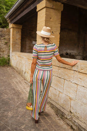 Pantalon crochet taille haute porté par une femme, vue de trois-quarts, muret, chapeau