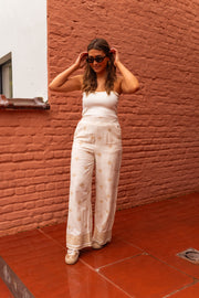 Pantalon à motifs effet lin porté par une femme, vue de trois-quarts, lunettes de soleil, main dans les cheveux