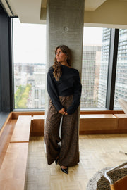 Pantalon fluide léopard porté par une femme, vue de trois-quarts, pilier, haut noir