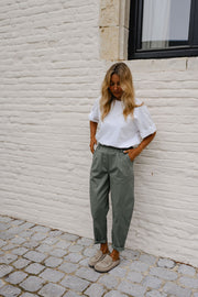 Pantalon barrel légèrement court porté par une femme, silhouette entière, t-shirt blanc, de face